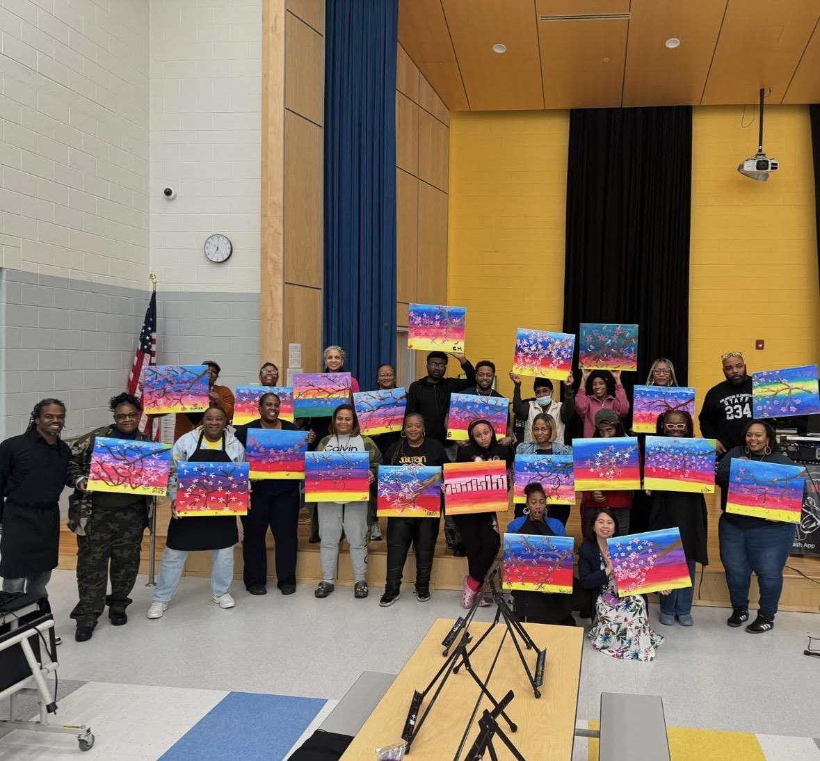 Large group showing cherry blossom paintings at a school event
