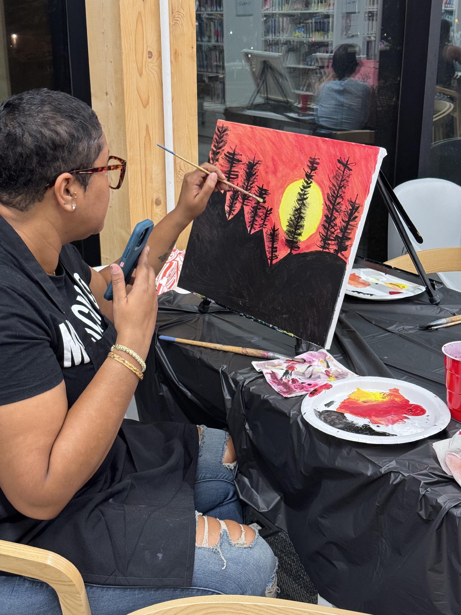 Participant painting a sunset landscape on canvas
